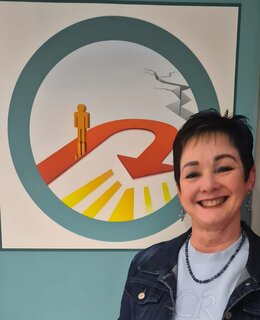 Alda Oosthuizen in her consulting room, in front of a mural depicting the U-turn logo.